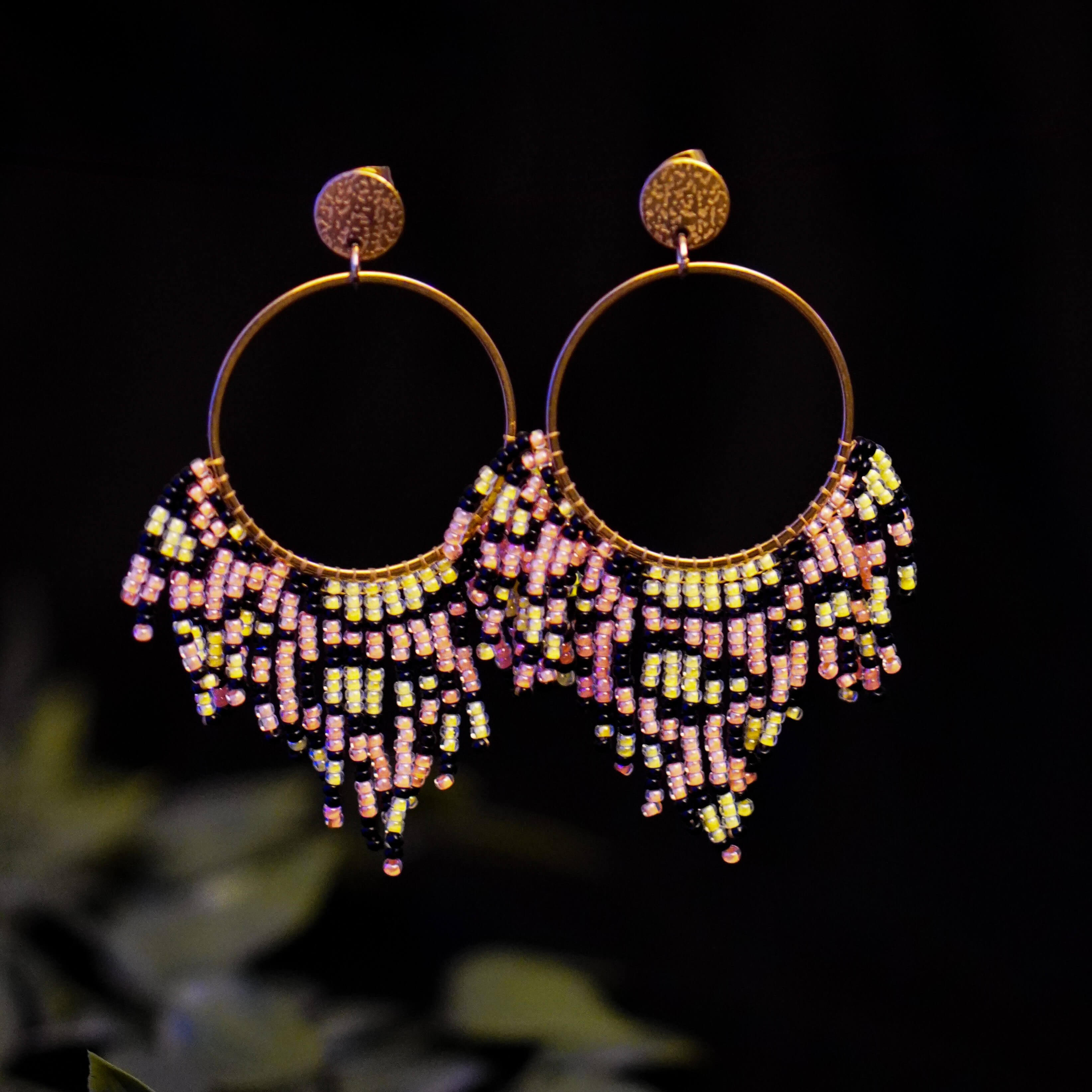 Neonowe kolczyki UV w kolorach pomarańcz i żółć, z czarnym konturem panterki.