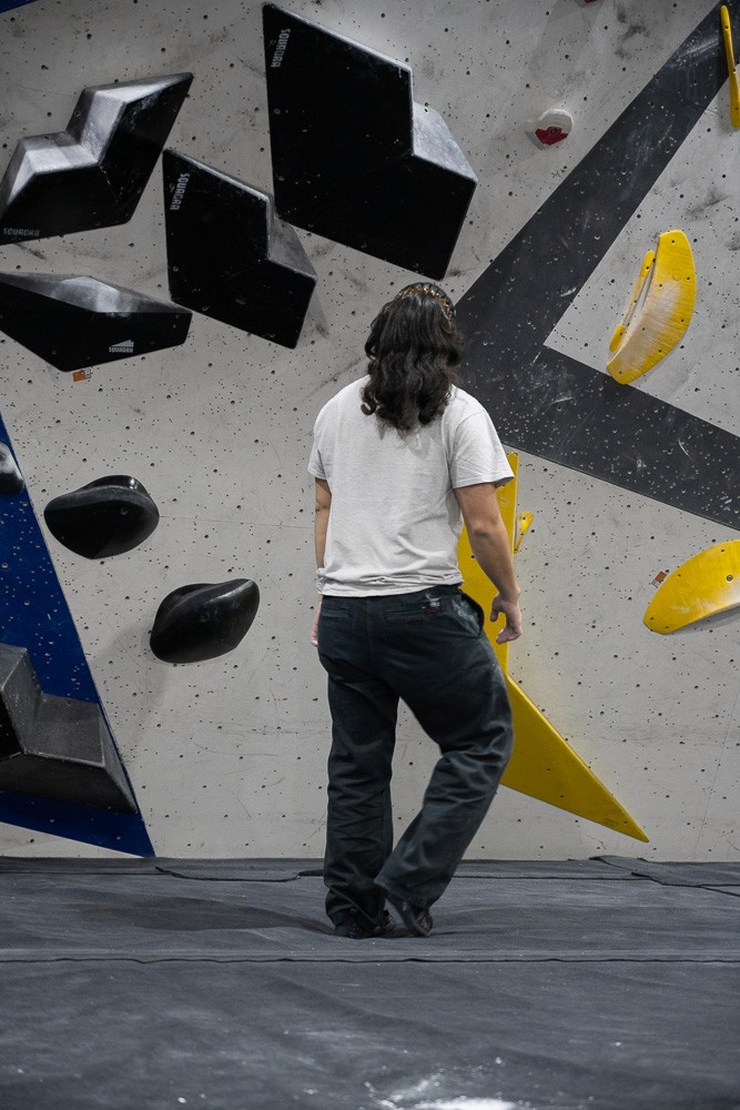 man  looking up at climbing wall