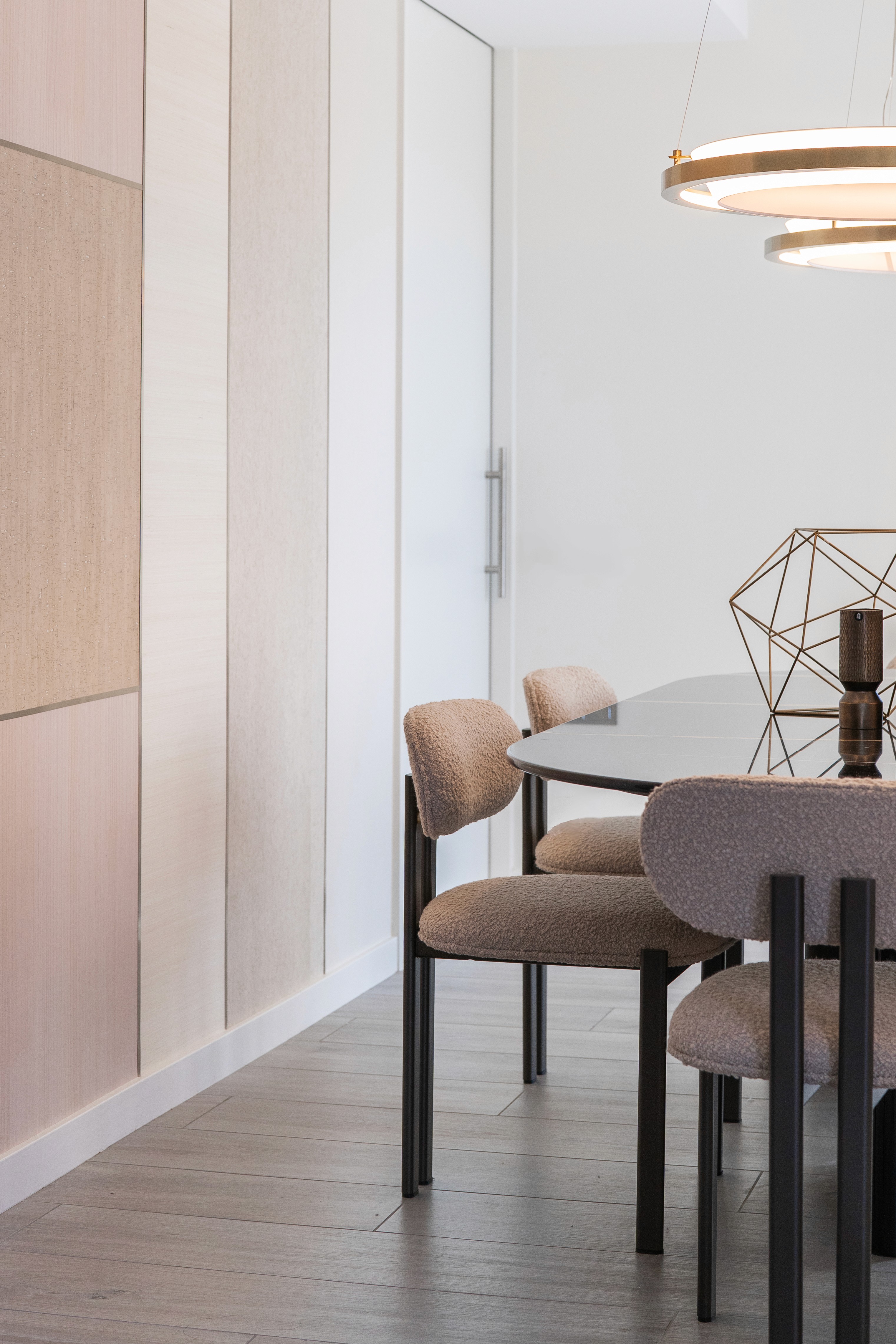 Zona de comedor con mesa de mármol oscuro y sillas de tela