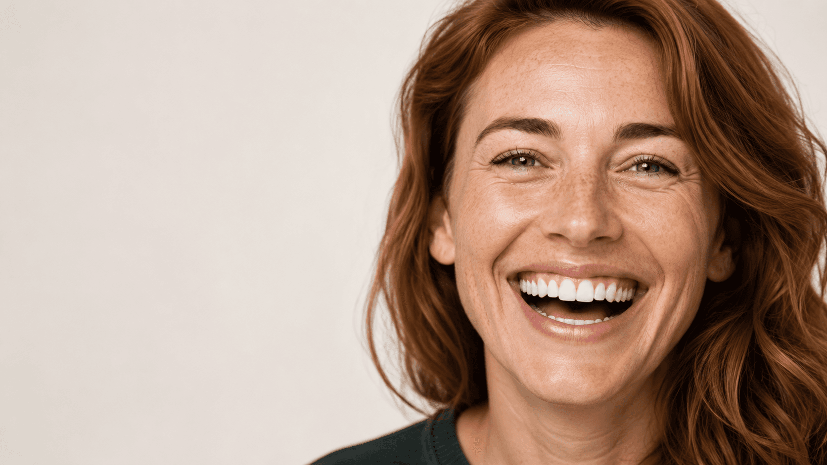 Woman with long auburn hair smiling brightly