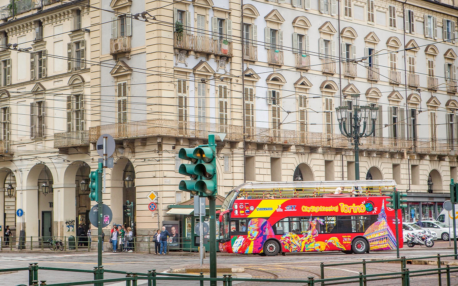 Turin hop-on hop-off buss som passerer en historisk bygning nær Lavazza-museet.