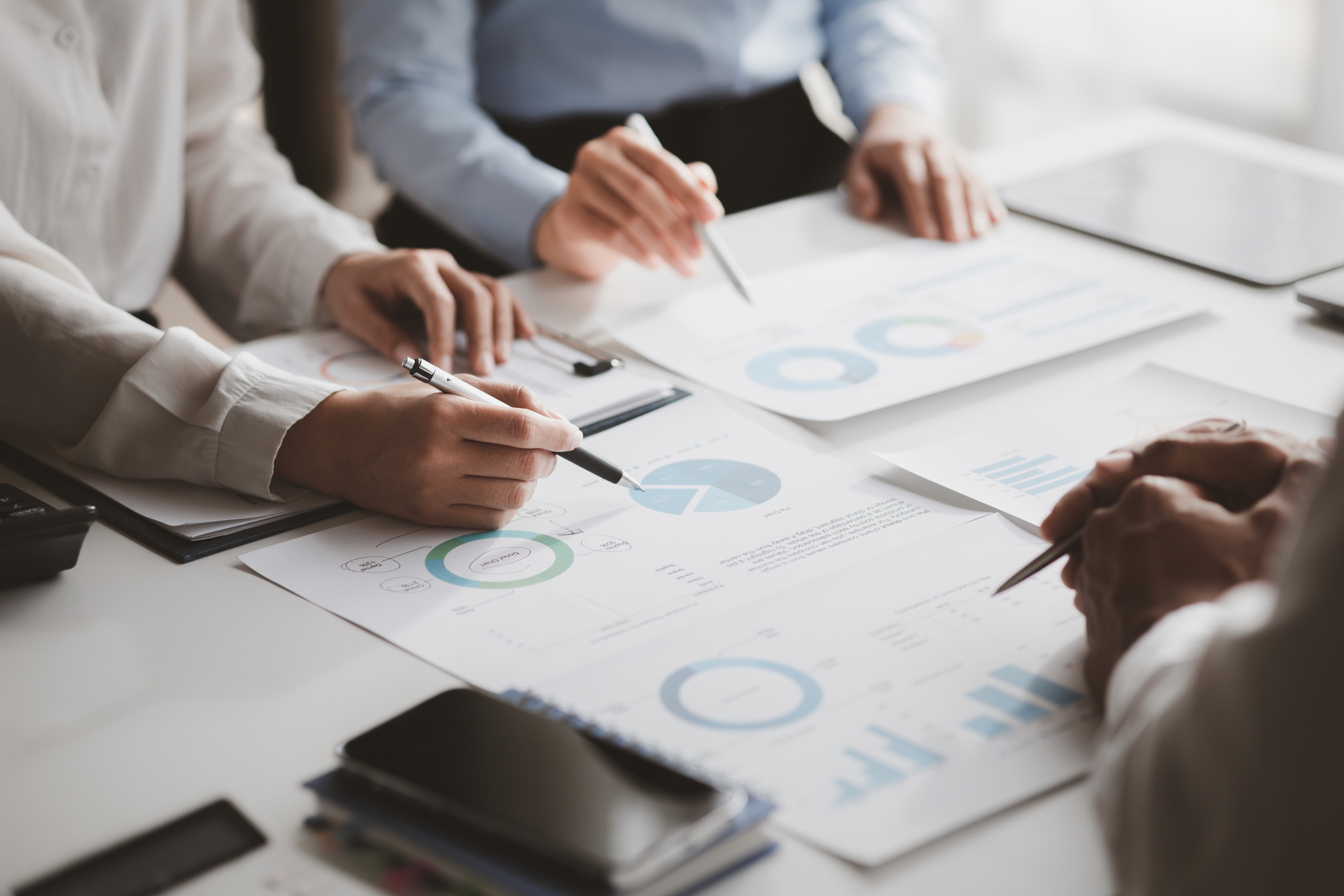 Professionals analysing financial reports together, representing a business consultant focused on understanding revenue performance and outcomes.