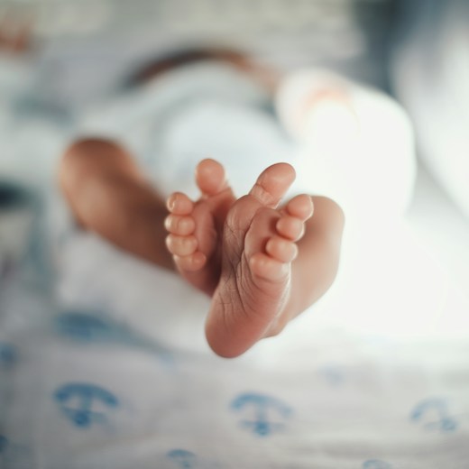 Pies de un recién nacido en la cuna: alta del bebé en el seguro de salud en sus primeros 30 días