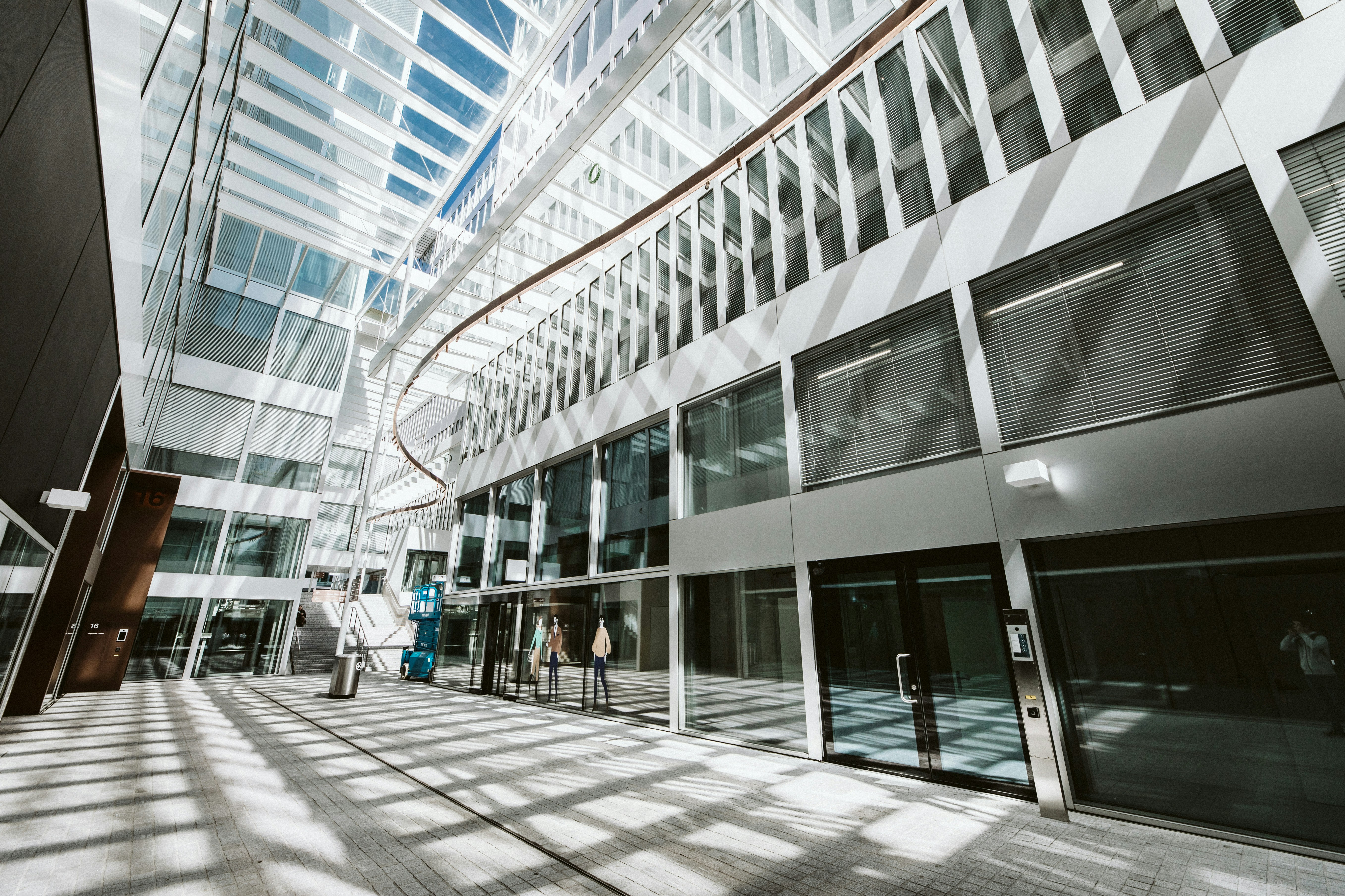 people walking on sidewalk near glass building during daytime