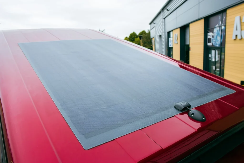 Semi-flexible solar panel fitted to a red pop-top roof