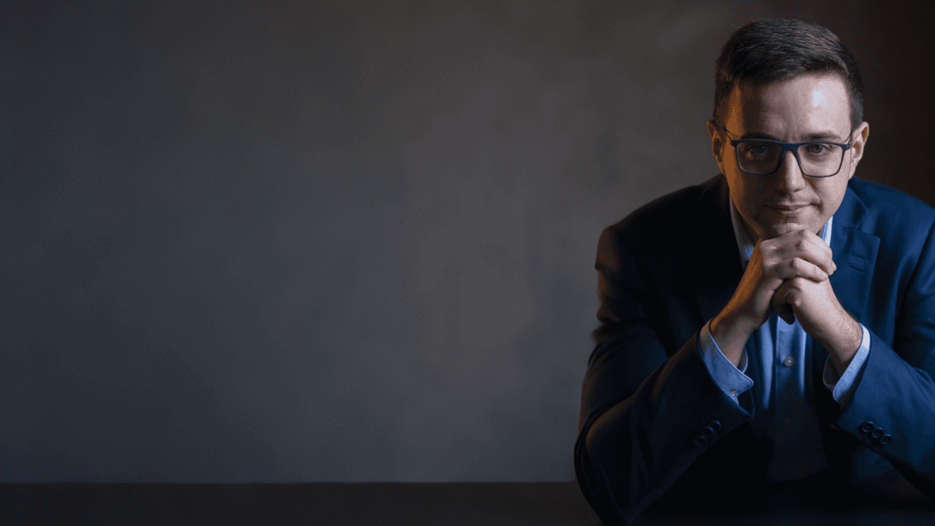 woman in blue tank top standing beside white wall