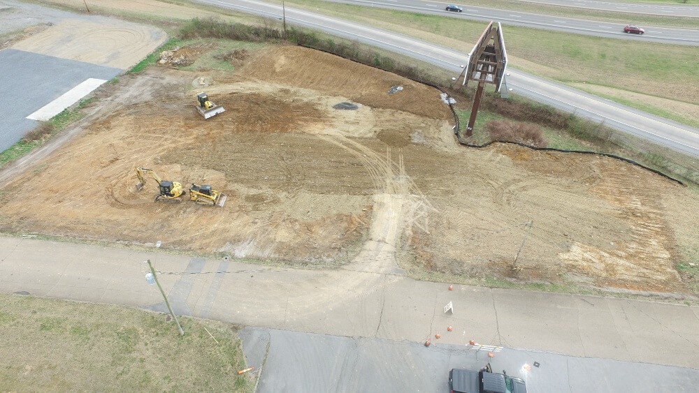 High altitude drone shot of lot being graded with construction equipment on site