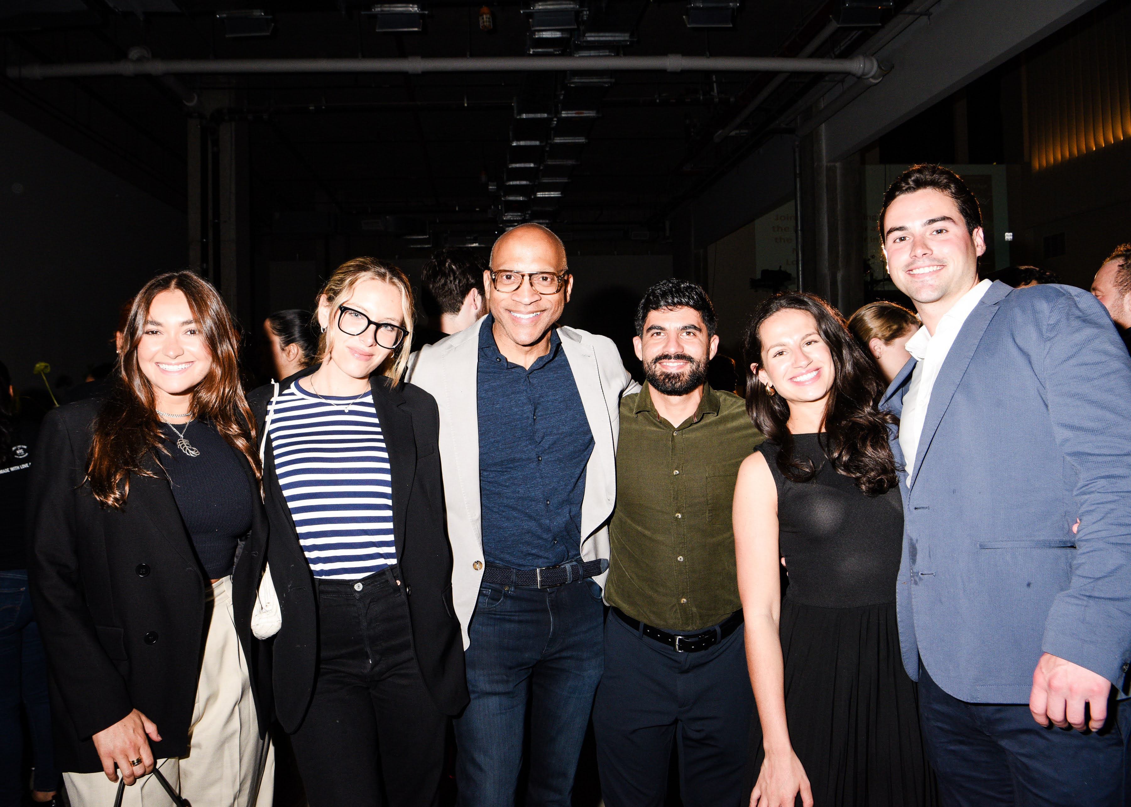 Six people attending an event pose for a friendly photo