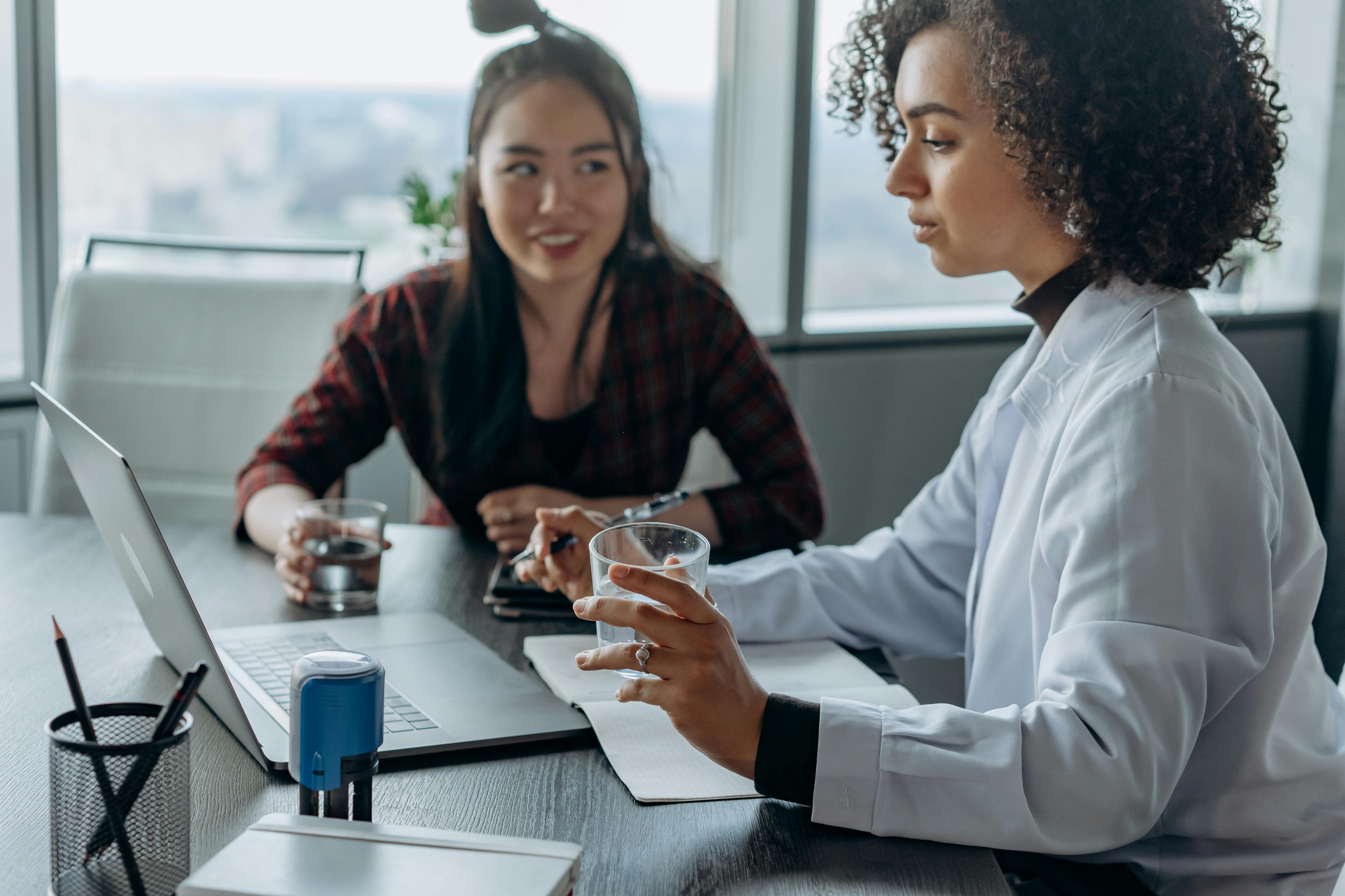 Businesswomen collaborating in work talking about cold email drawbacks