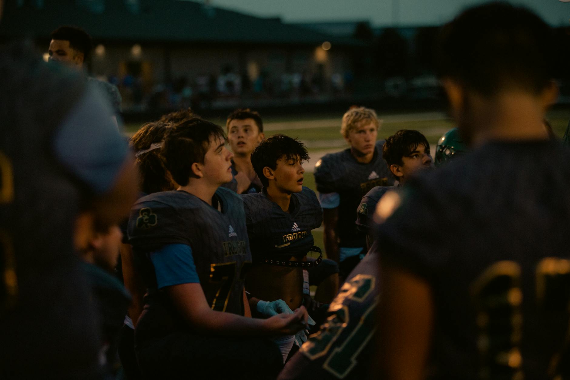 High school football player reviewing plays during summer training
