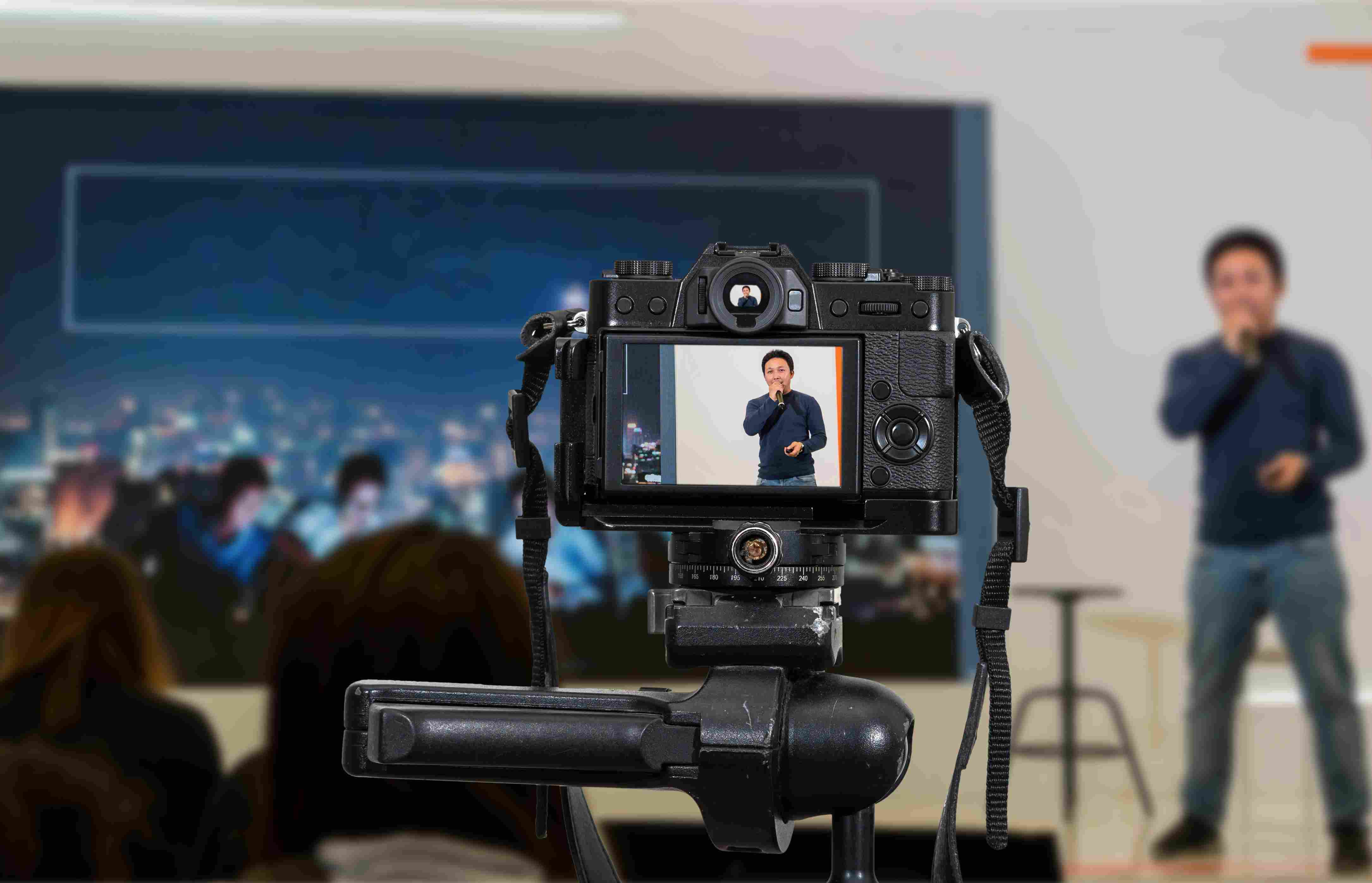 Live event webcast setup capturing a speaker on stage through a professional camera