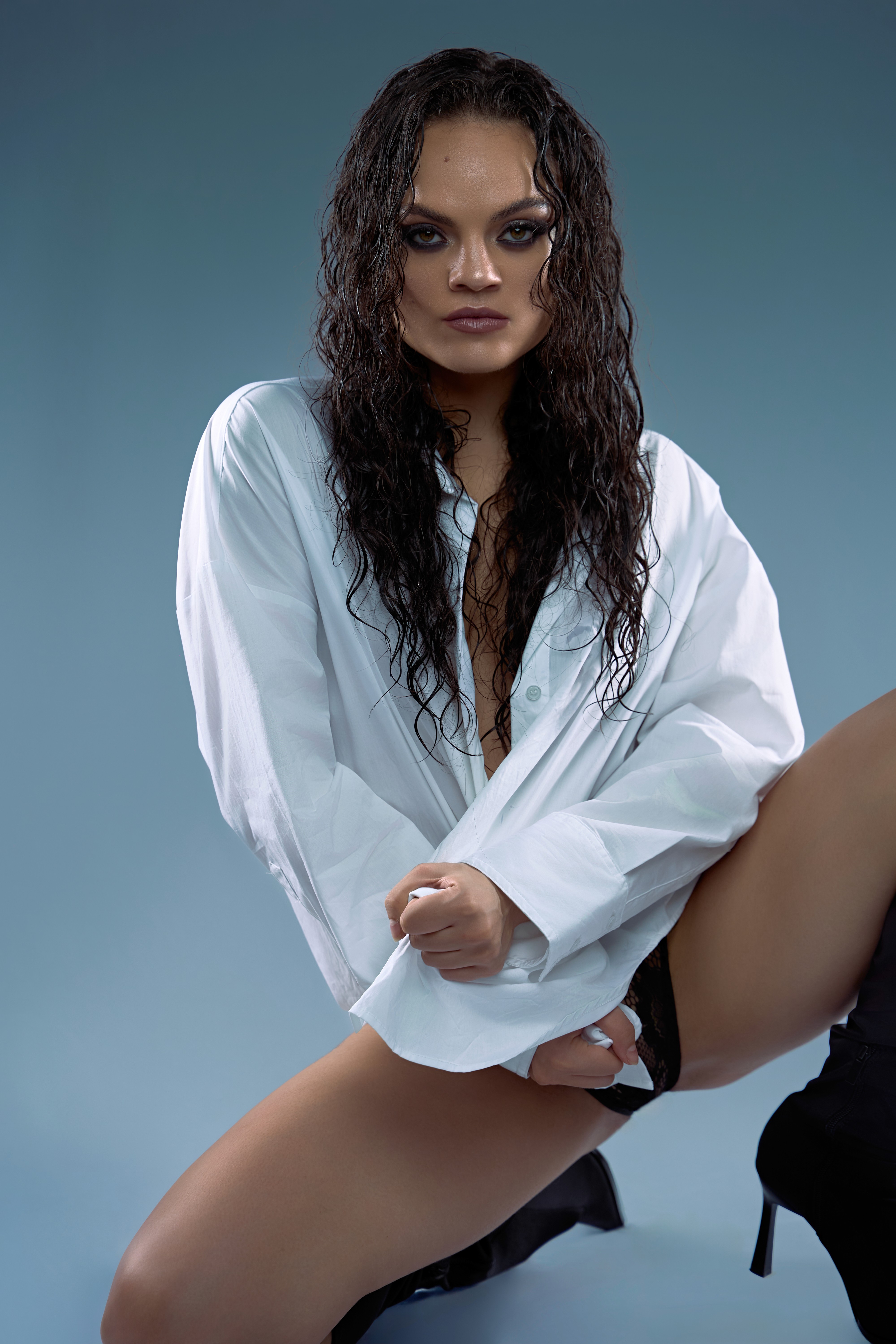 Fotografía de retrato de moda de una mujer con cabello mojado y camisa blanca en estudio, capturando autenticidad y sofisticación con un toque cinematográfico en Palma, Mallorca, destacando la excelencia en dirección de arte y diseño.
