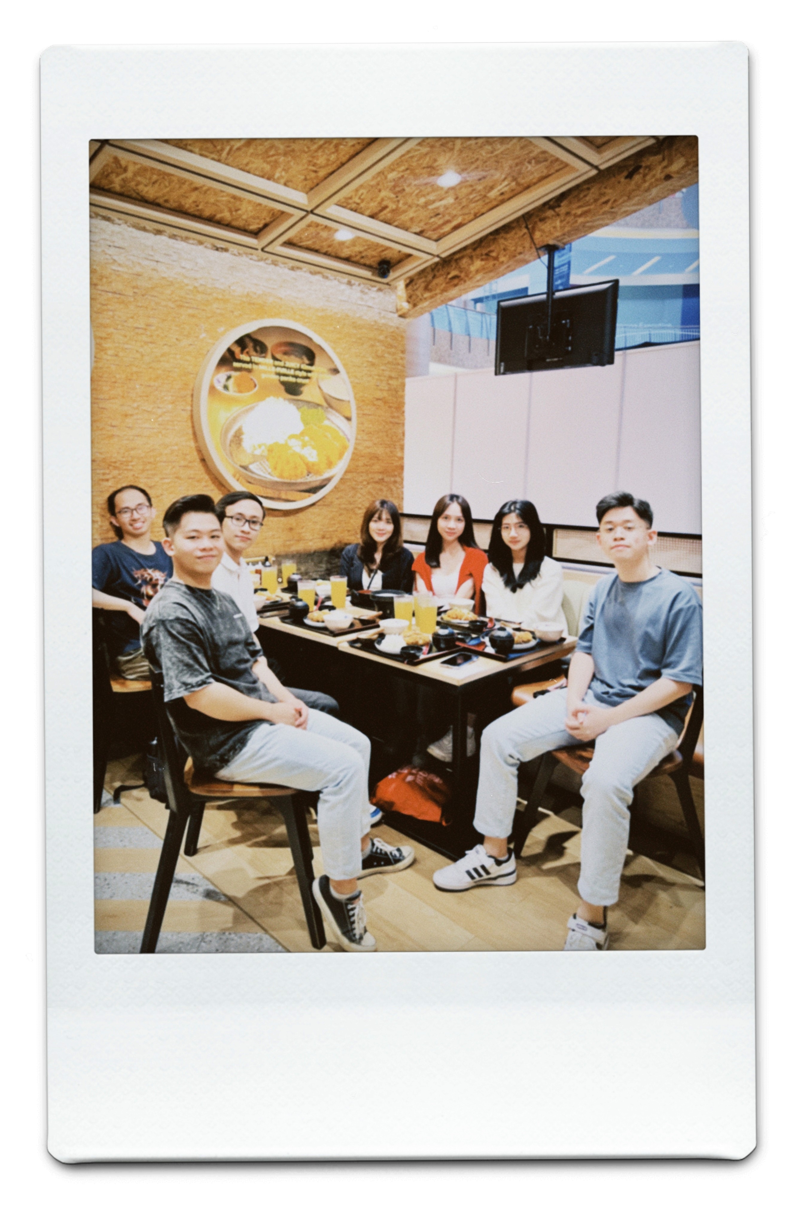 Green car under neon lights in a rainy city street