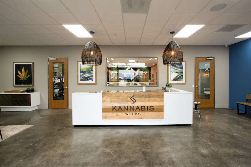 Interior of Kannabis Works featuring reception desk with brand logo and pendant lighting.