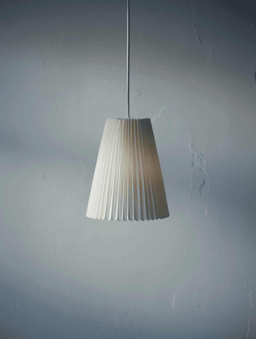 A modern, white pleated pendant lamp with a tapered design hangs from the ceiling against a textured gray background, creating a minimalist and elegant ambiance.