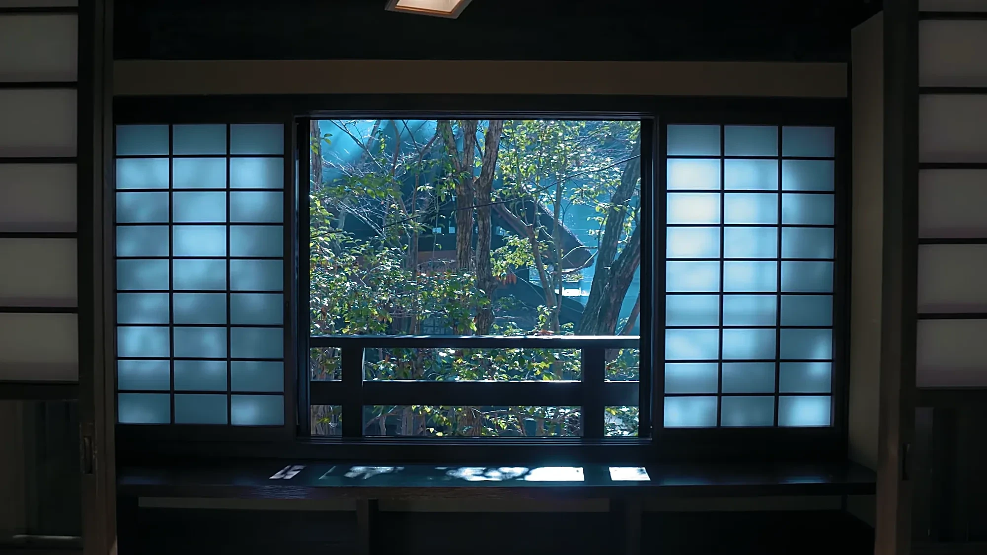 A tatami room with shoji open to a balcony and trees