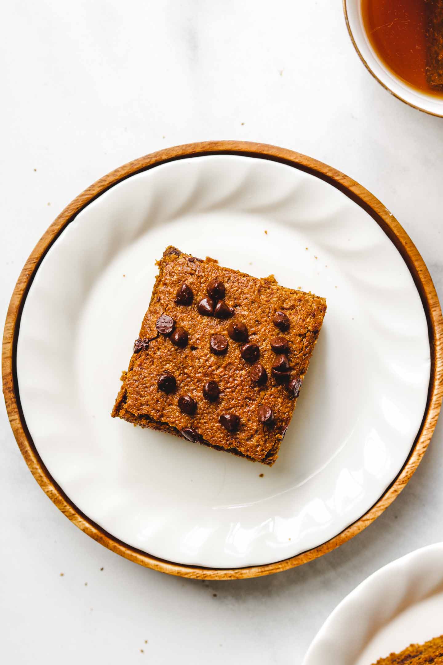 A close-up view of delicious chocolate pumpkin blondies, featuring a rich, fudgy texture with chocolate chips. The blondies are cut into squares.