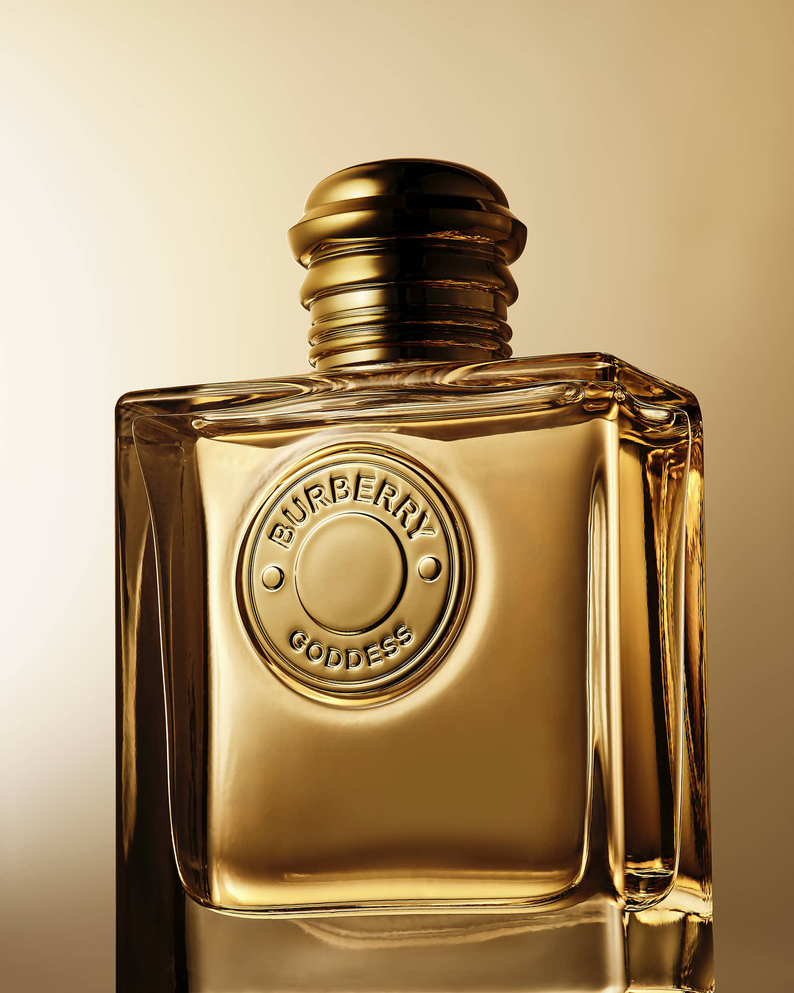 A close-up of a golden perfume bottle against a soft, warm background, showcasing its elegant design.