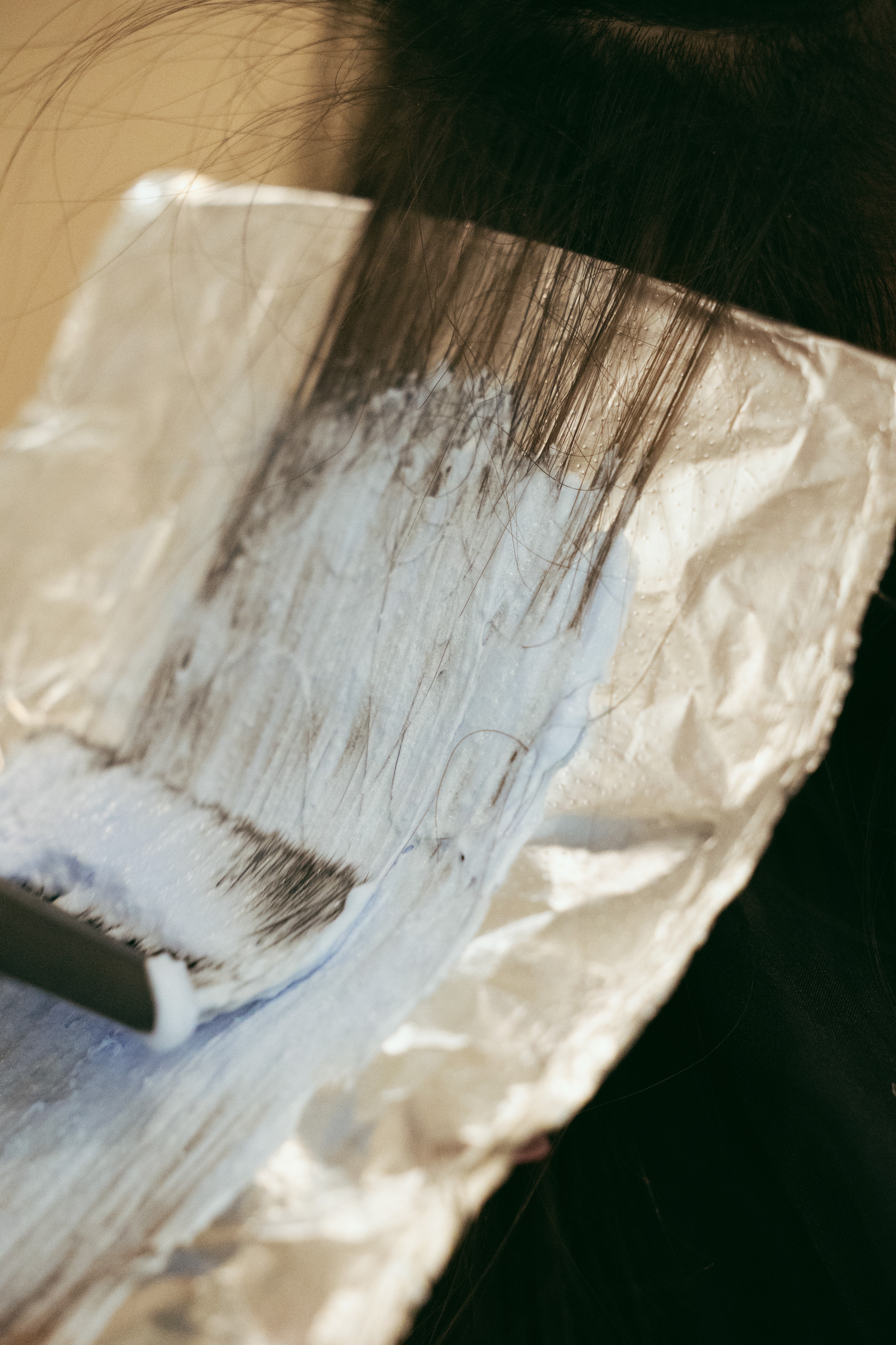 A cozy scene with warm sunlight casting stripes, featuring a potted plant and soft towels on a window sill.