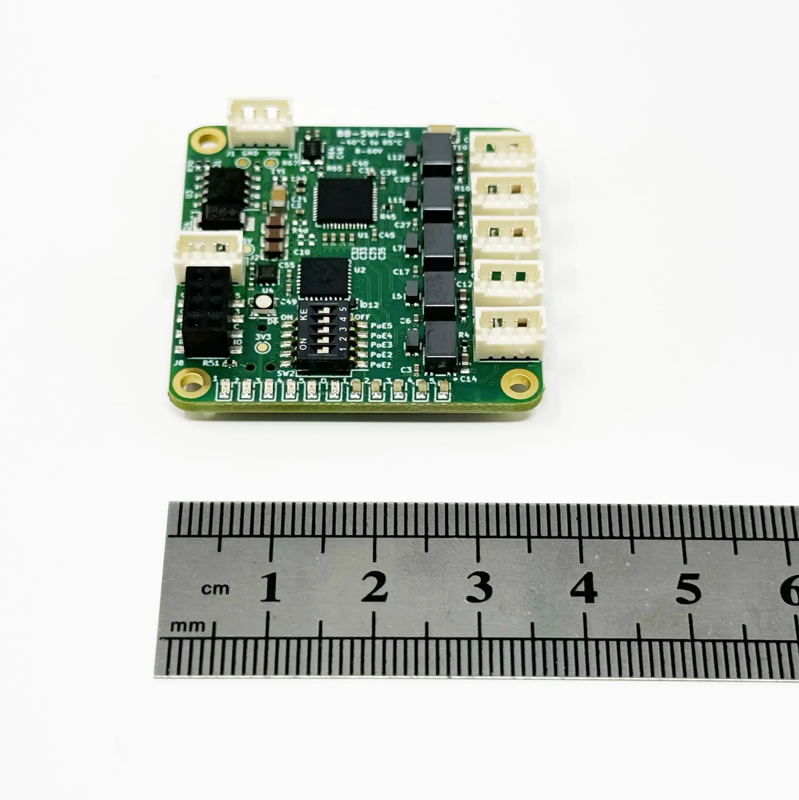 BotBlox miniature Ethernet switch PCB next to a ruler showing sub-5cm form factor for SWaP-constrained UAV and embedded applications
