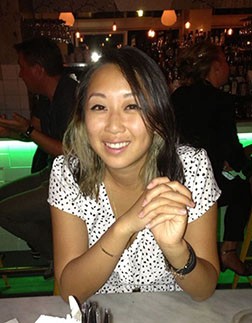 A photo of a woman wearing a white dress and sitting at a restaurant table.