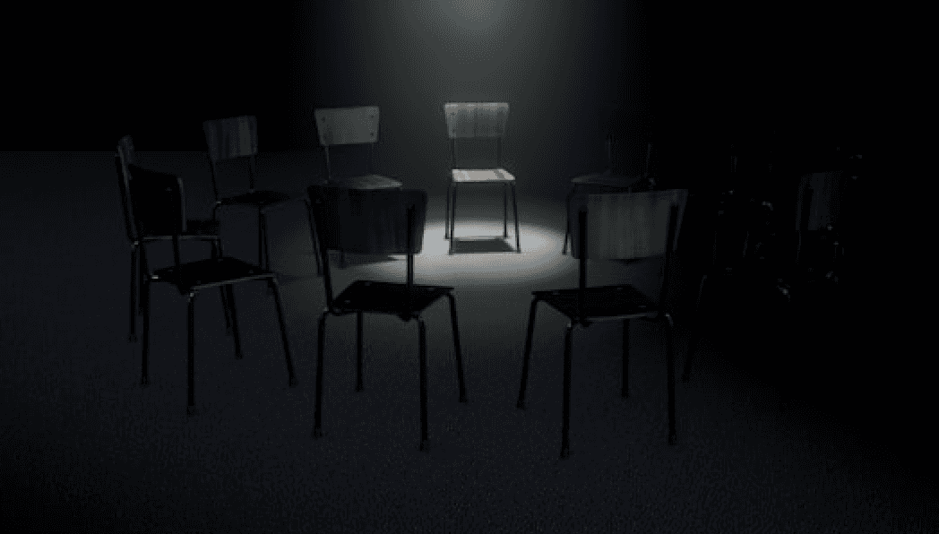 Spotlit chair in a circle of shadows on a dark floor