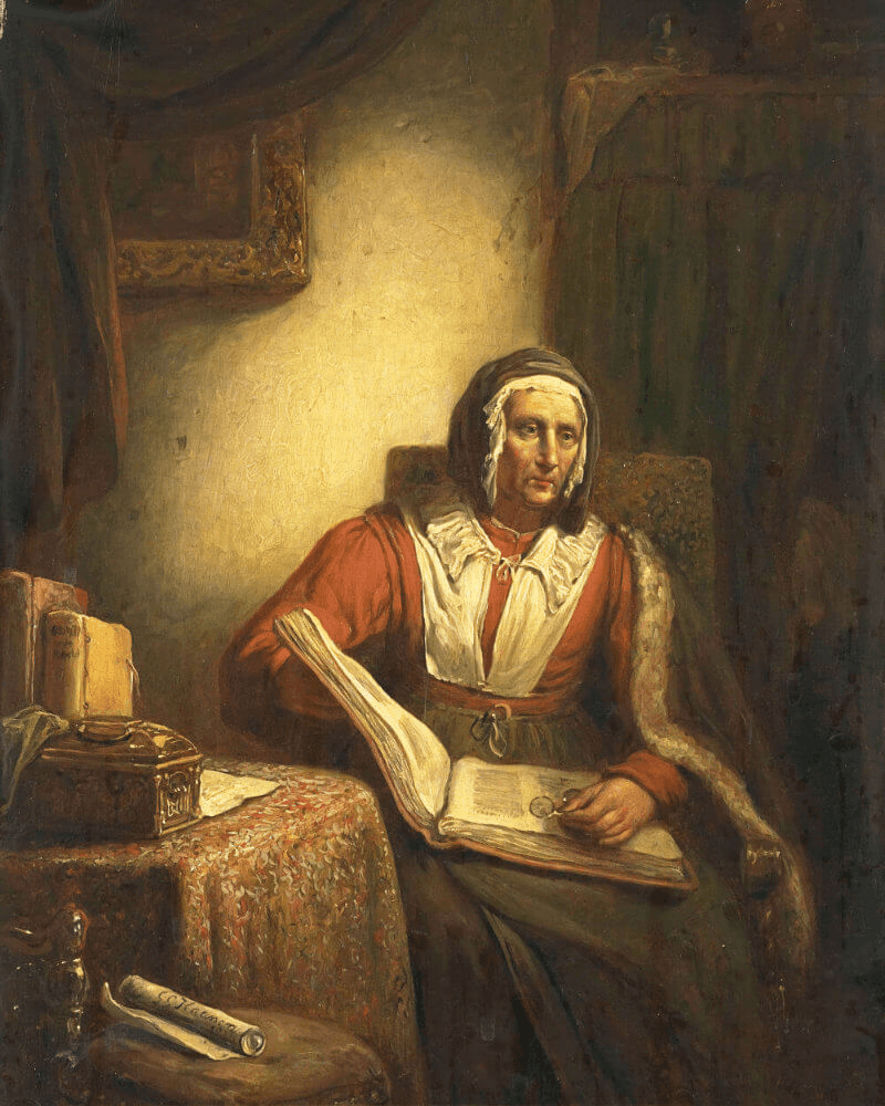 A figure seated at a table, focusing on a small object, surrounded by boxes in a softly lit room.
