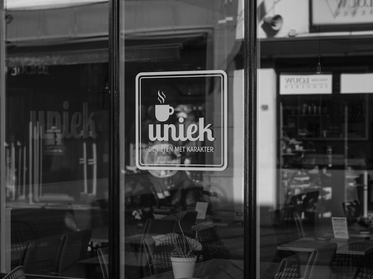 Fachada de tienda con logo Uniek en la puerta de cristal