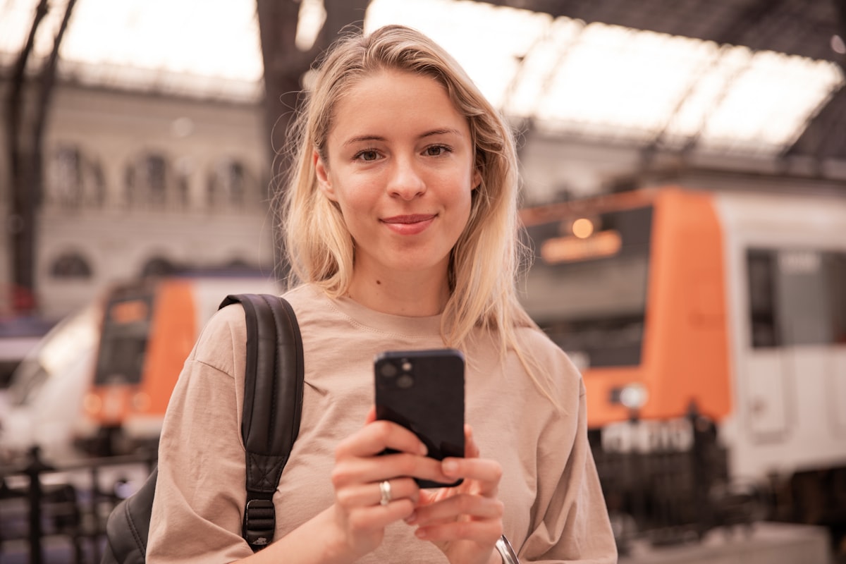 Traveler checking her phone in a train station
