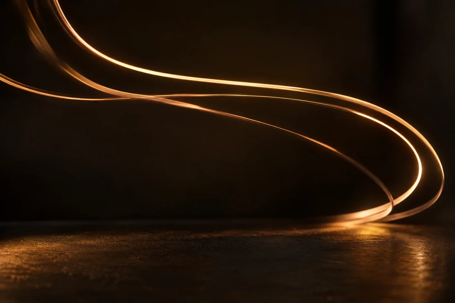 Three flowing thin amber light trails making smooth arcs in dark space, original kinetic light study