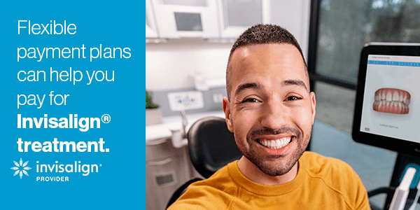 A smiling man in a dental clinic, sitting next to a computer screen displaying a digital image of teeth, highlighting his positive experience with Invisalign.