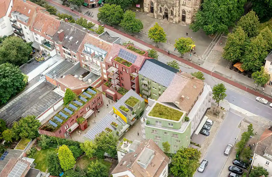 Isometrische Zeichnung eines Bauprojekts mit mehreren Gebäuden und markierten Strukturen in Rot