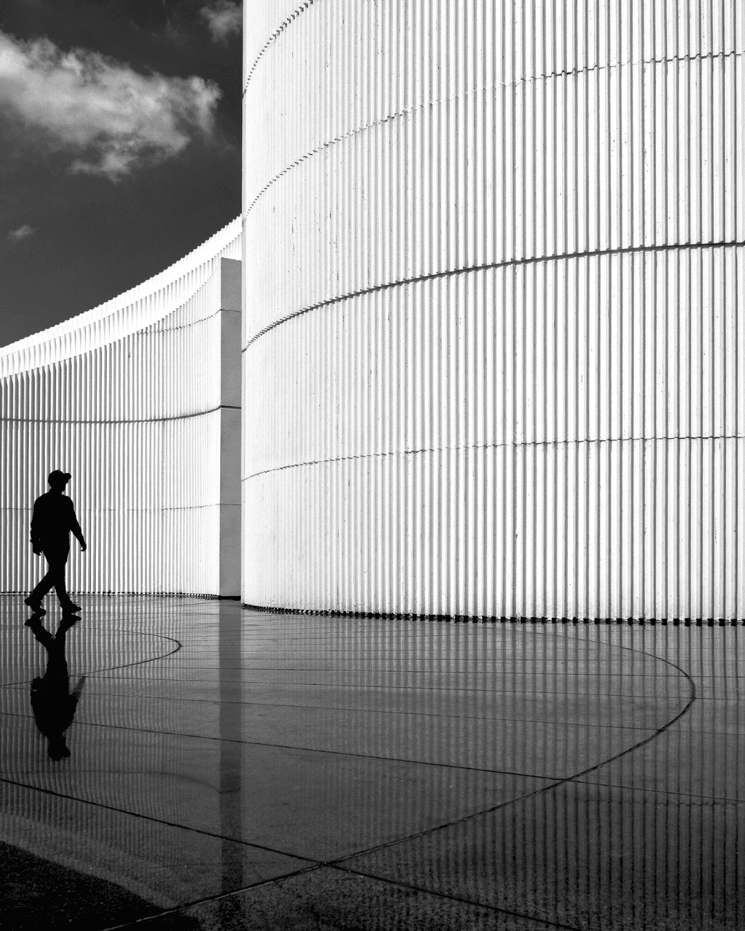 Young person with curly hair wearing blue clothing, smiling at camera