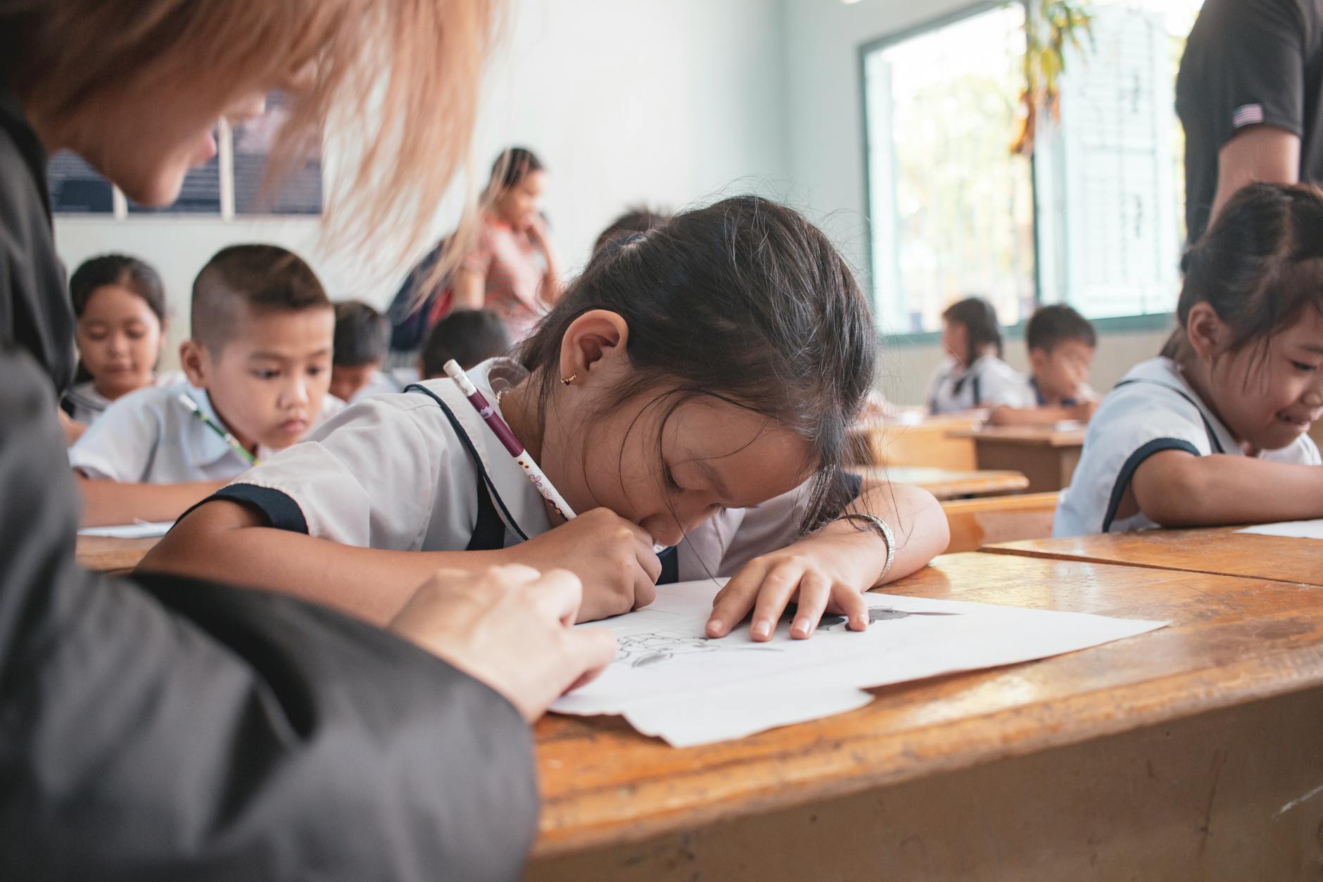 An aspiring kindergarten teacher sits on a colorful rug reading a picture book to a group of engaged children.