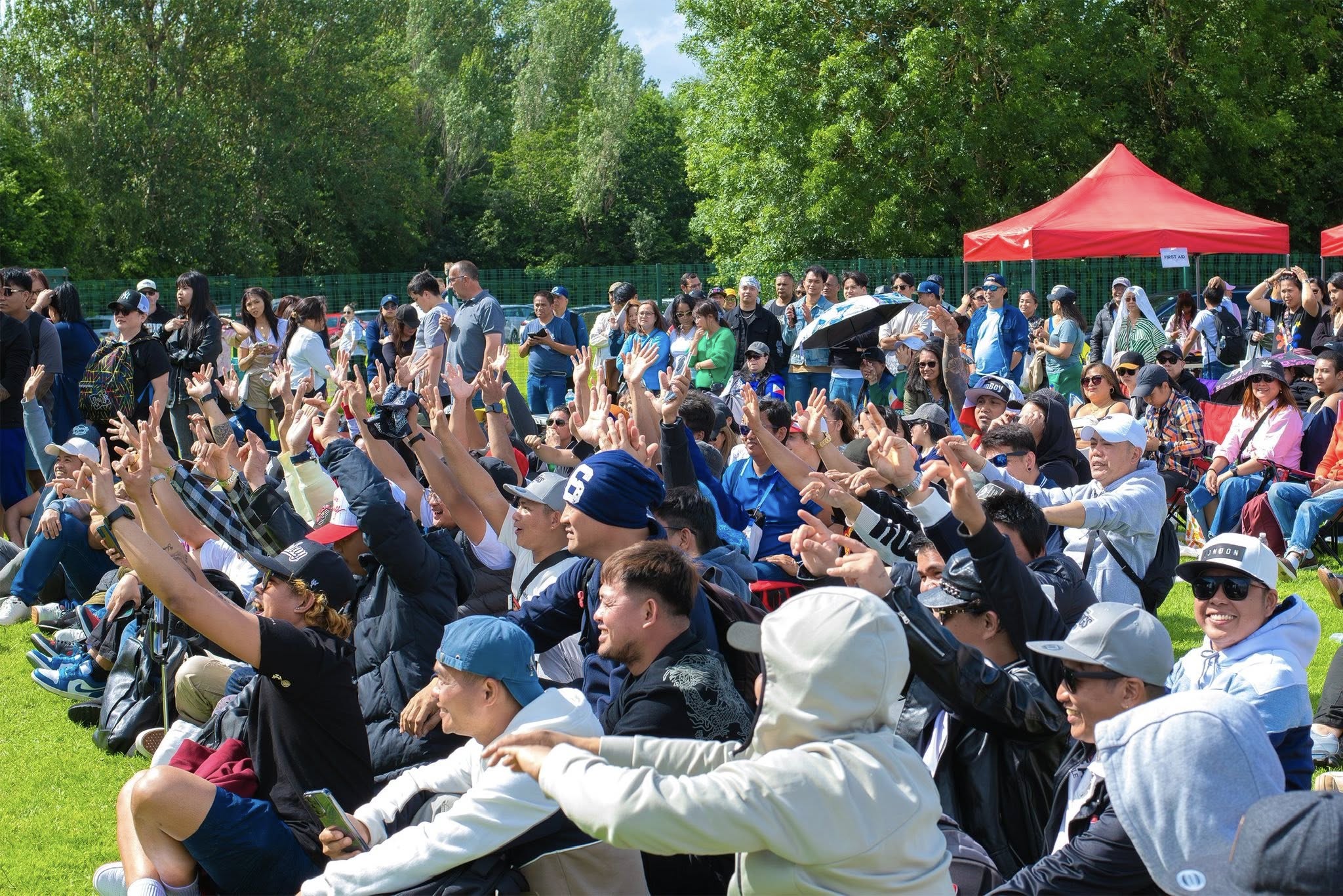 Lively crowd raising their hands toward a stage