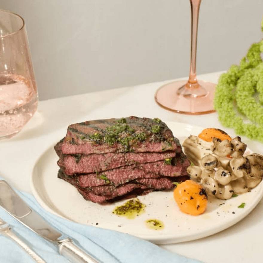 A plate with steak, vegetables, and a glass of wine.