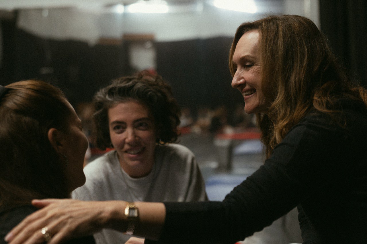 woman in blue tank top standing beside white wall