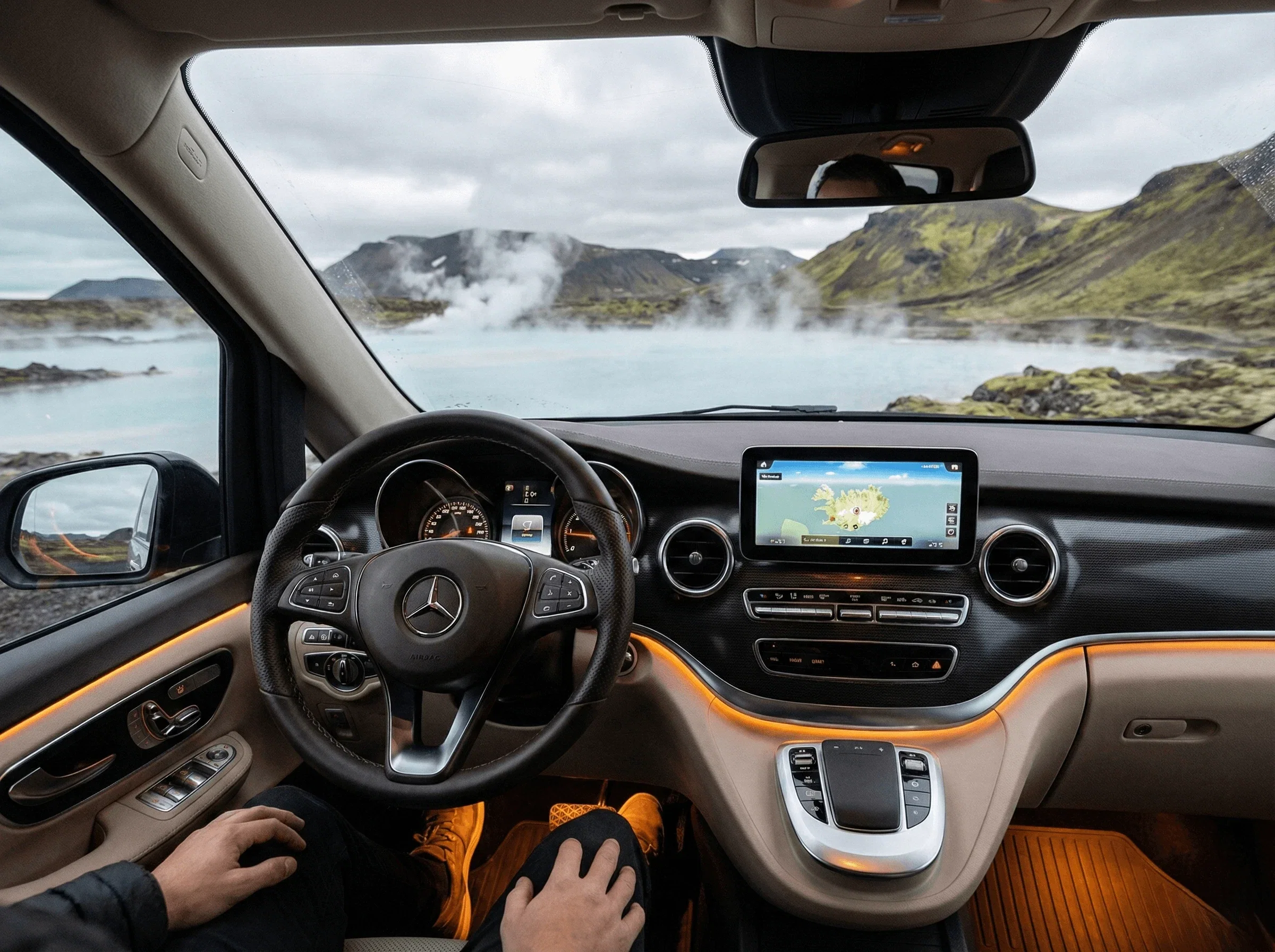 Rear view of a red camper van with open doors, towels hanging, and chairs set up near a steaming hot spring.