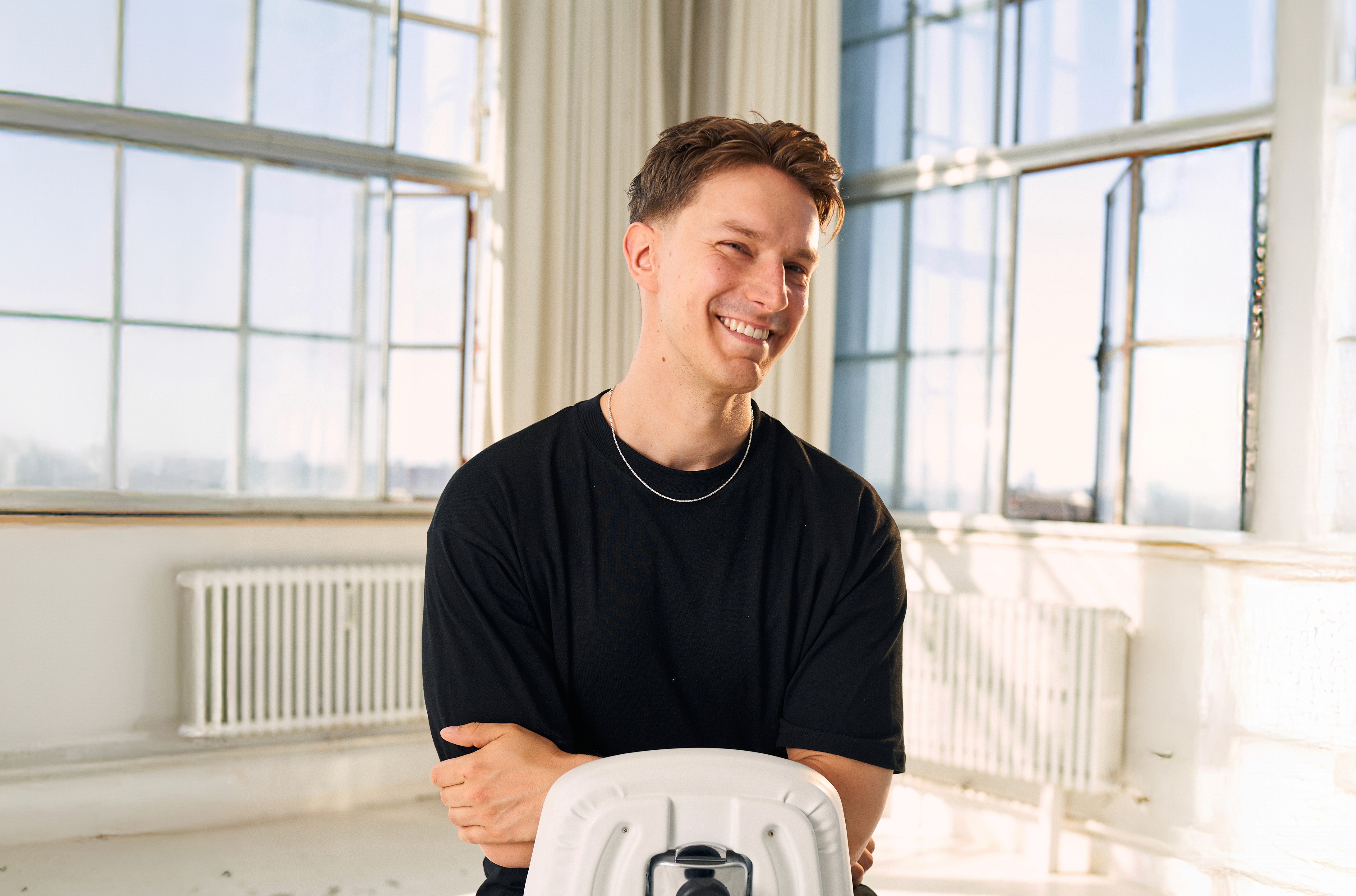 A close-up of a person wearing green-tinted glasses, with a serious expression and smooth skin.