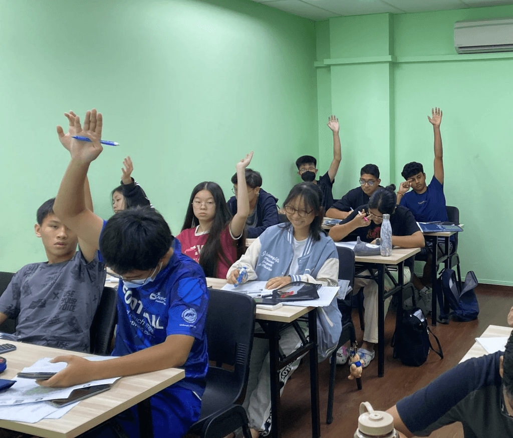 Students at Physics Academy rasing their hands