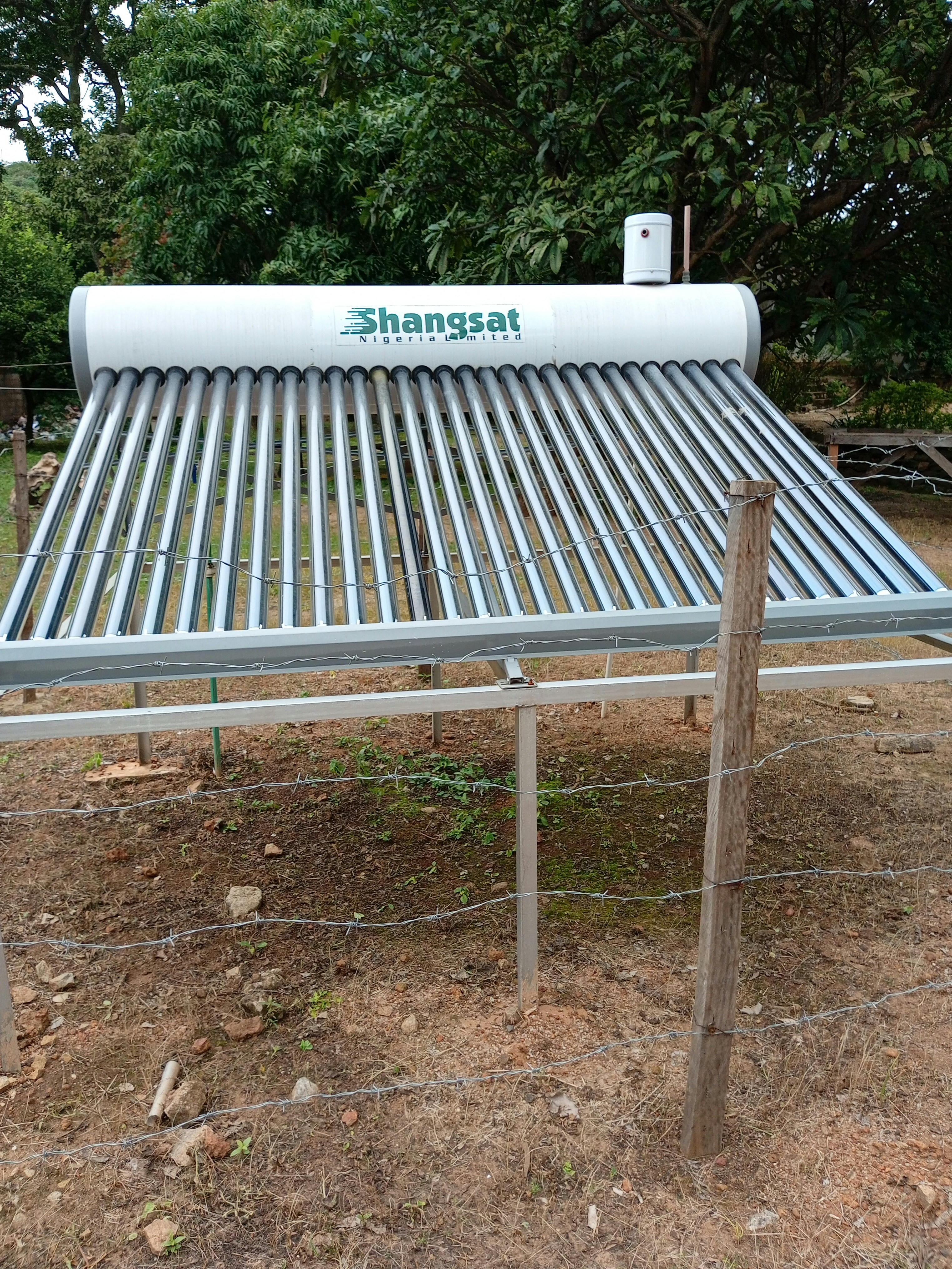 A solar water heater sitting on top of a field