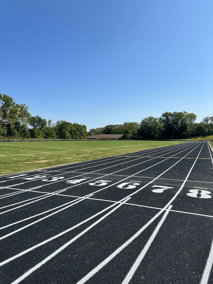 Close-up of a standard outdoor running track with numbered lanes.