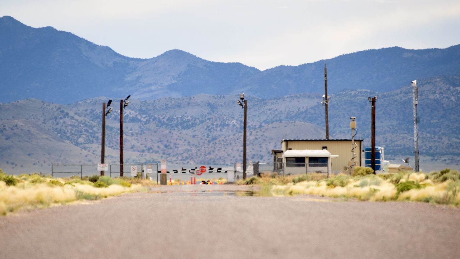 Restricted entrance gate to Area 51 military base in the Nevada desert with security cameras and stop signs