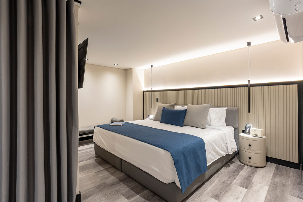 Hotel moderno en Laureles Medellín, habitación Altus Garden con ventanales y luz natural frente a muro verde natural y diseño de bienestar