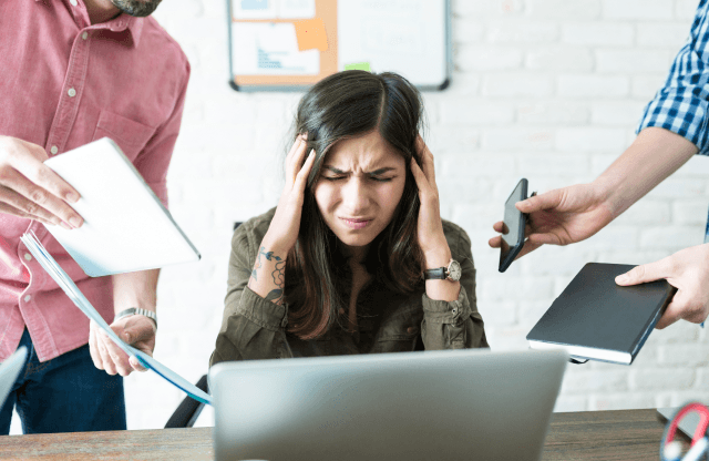 Two colleagues discussing data on a laptop screen.