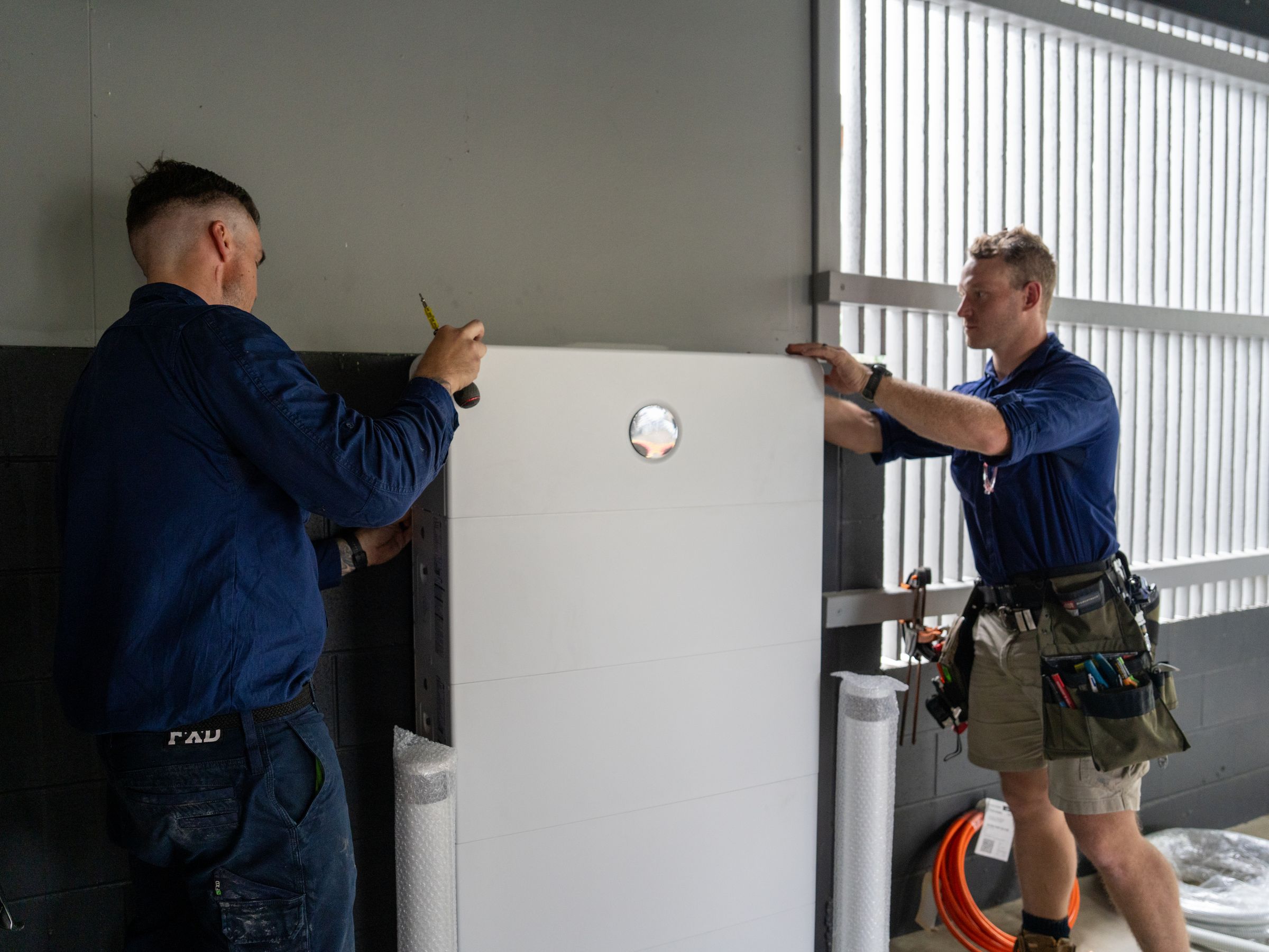 Josh and Stewart from Peak Electrical installing a home battery