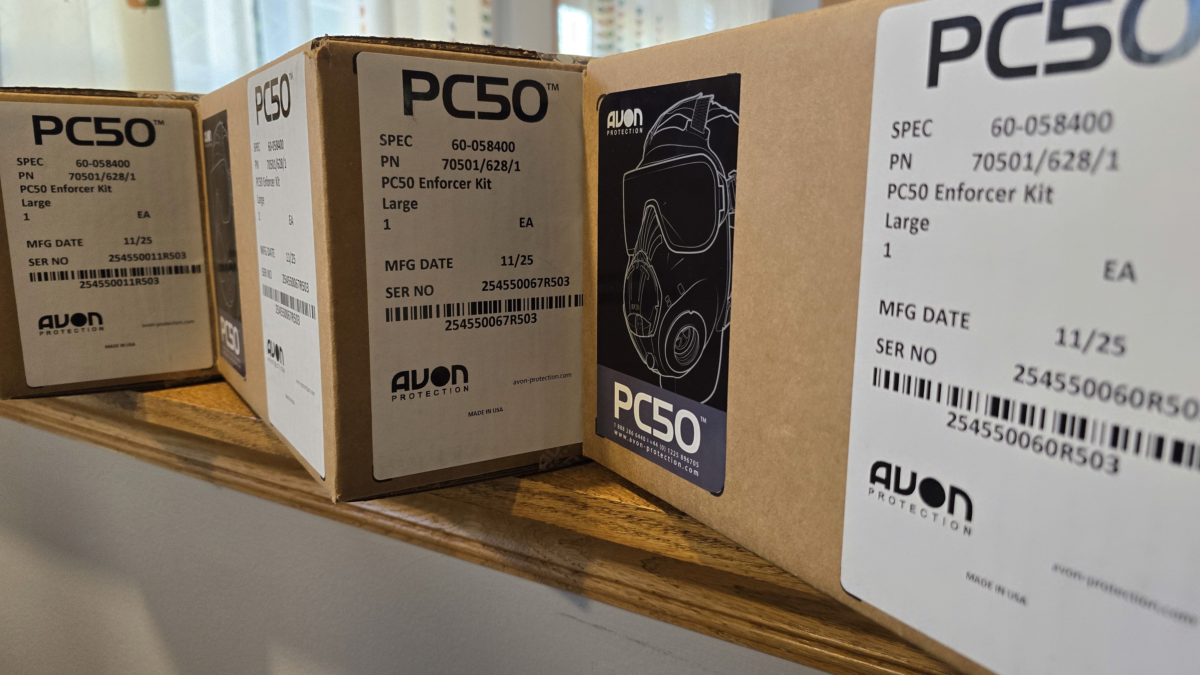 Close-up of a dark green leaf showing its textured surface and central vein against a muted background.