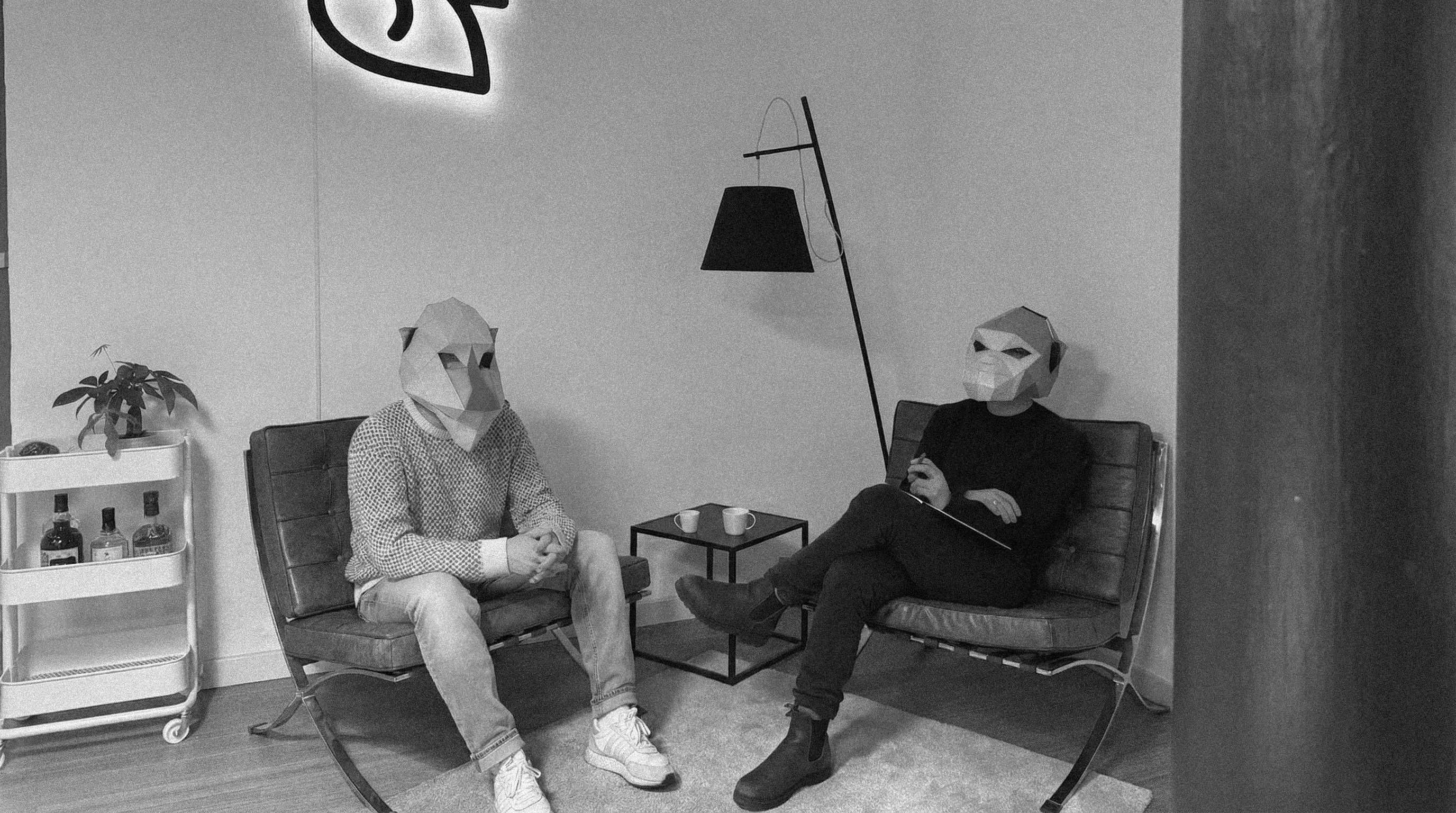 Collaborative work session overhead view of six people collaborating at a rustic wooden table with coffee, papers, and a laptop