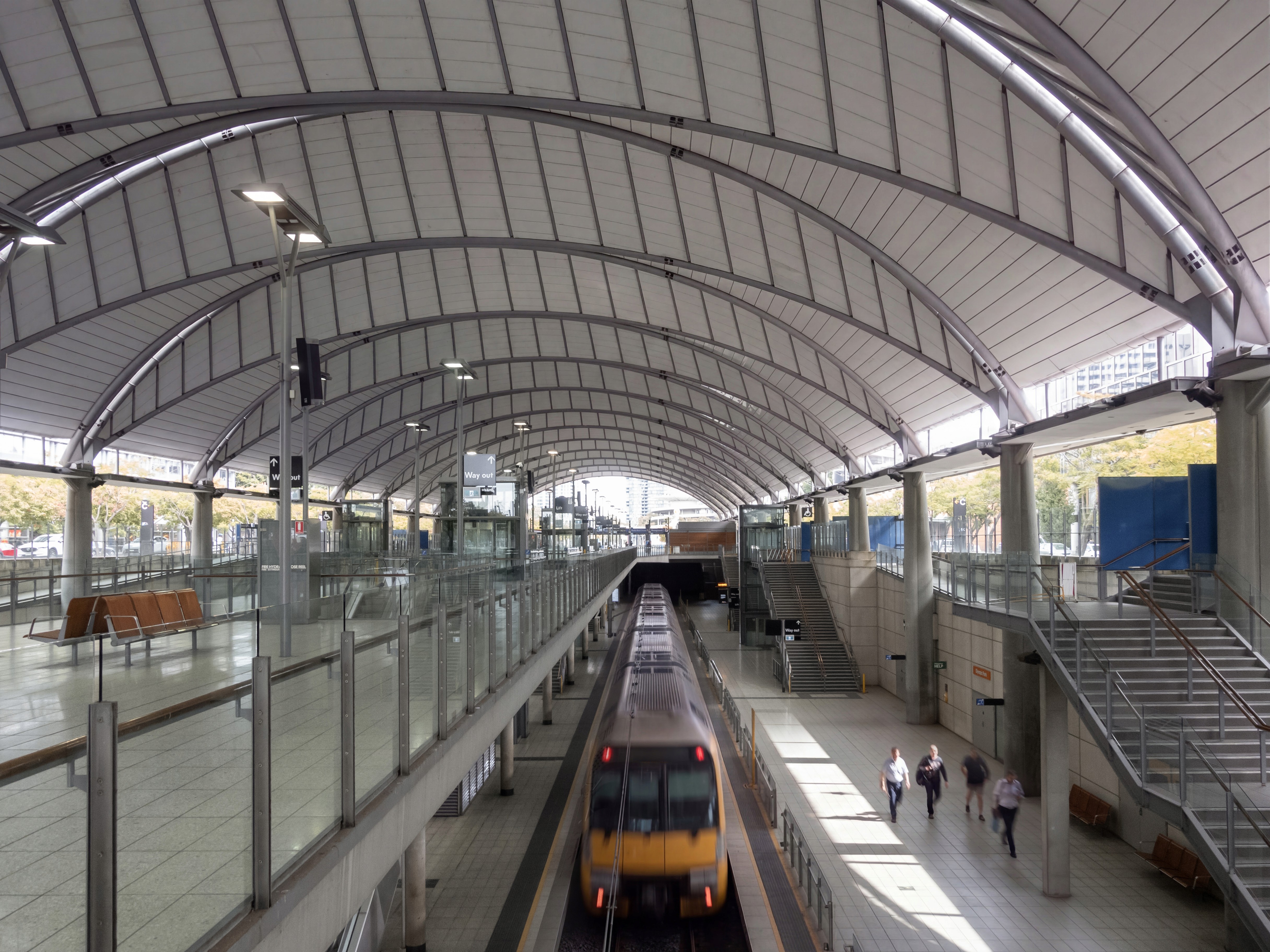 Train movement and commuter flow make circulation legible, revealing how the station’s section, platforms, and vertical connections are structured to support continuous, real-time use.