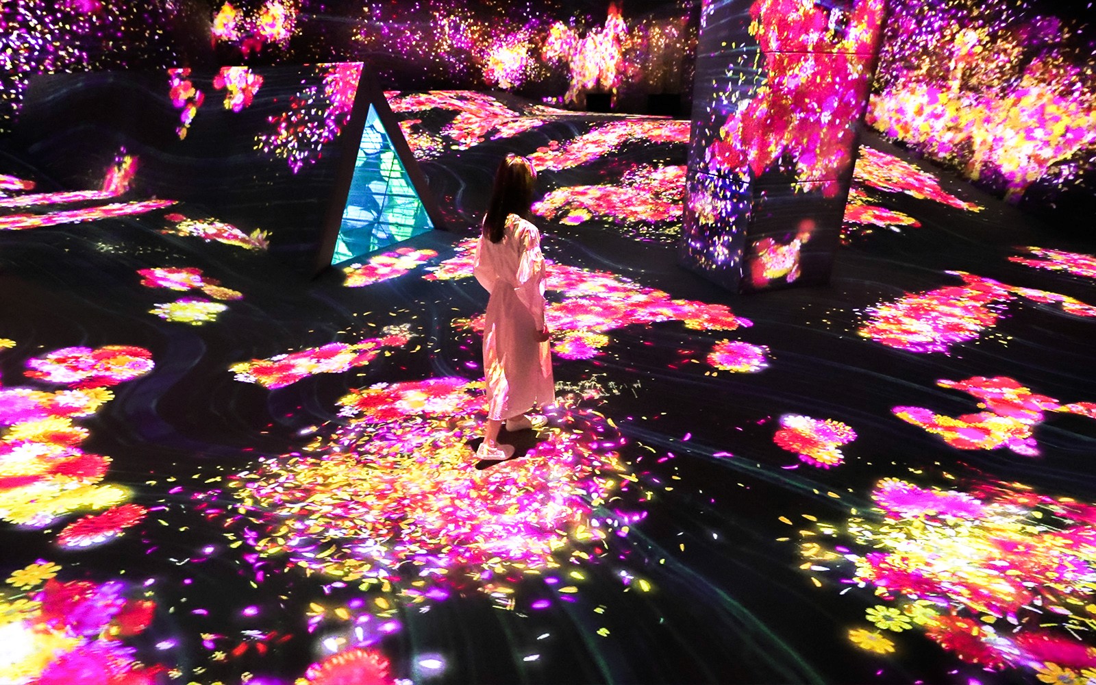 Visitor exploring vibrant digital art installation at E・ZO FUKUOKA teamLab Forest.